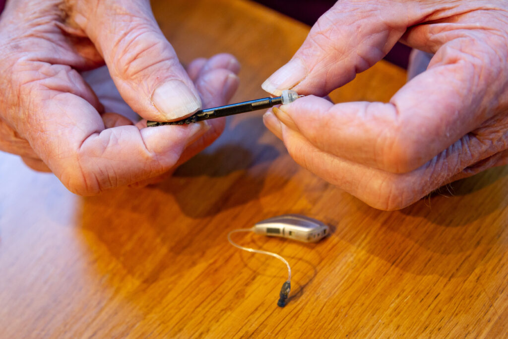 man holding hearing aid tool